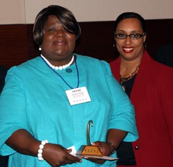 Prairie State College student Favian Apata (left)
accepts her $500 Paul Simon Student Essay Contest scholarship from State Senator Toi Hutchinson.