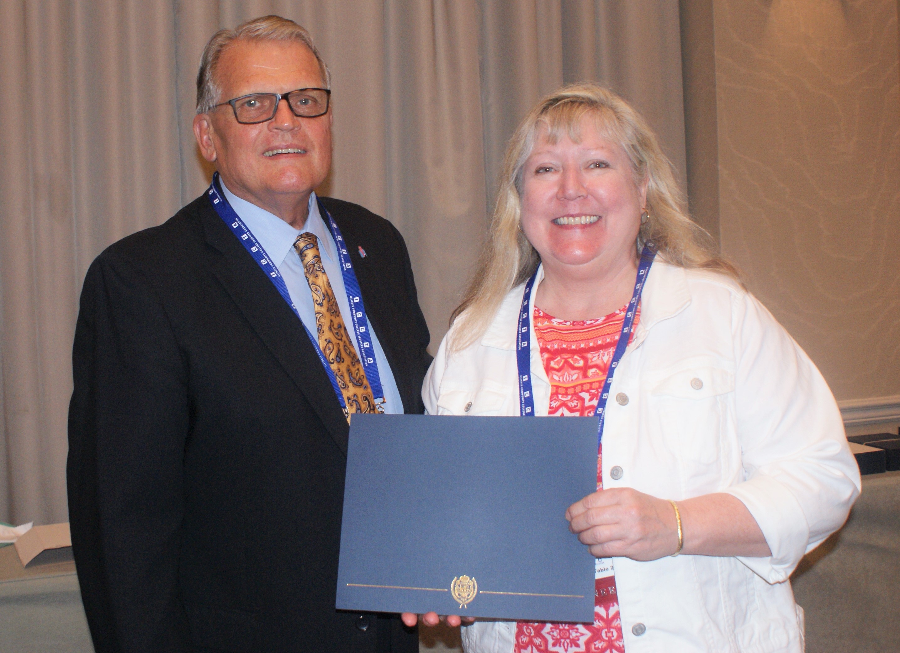 McHenry County College student Karen Russ accepts her $500 Paul Simon Student Essay Contest scholarship
from Illinois Community College System Foundation president Dr. Joe Kanosky.