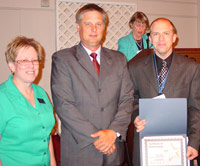 Jason Wallace (far right) accepts ICCTA's 2006 Gigi Campbell Student Trustee Excellence Award from Heartland Community College trustee Cindy Brand and president Jon Astroth.