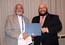 Oakton Community College student Joshua Rodriguez accepts his $1,000 Gandhi/King Peace Essay Scholarship
from Oakton Community College trustee emeritus Jody Wadhwa.